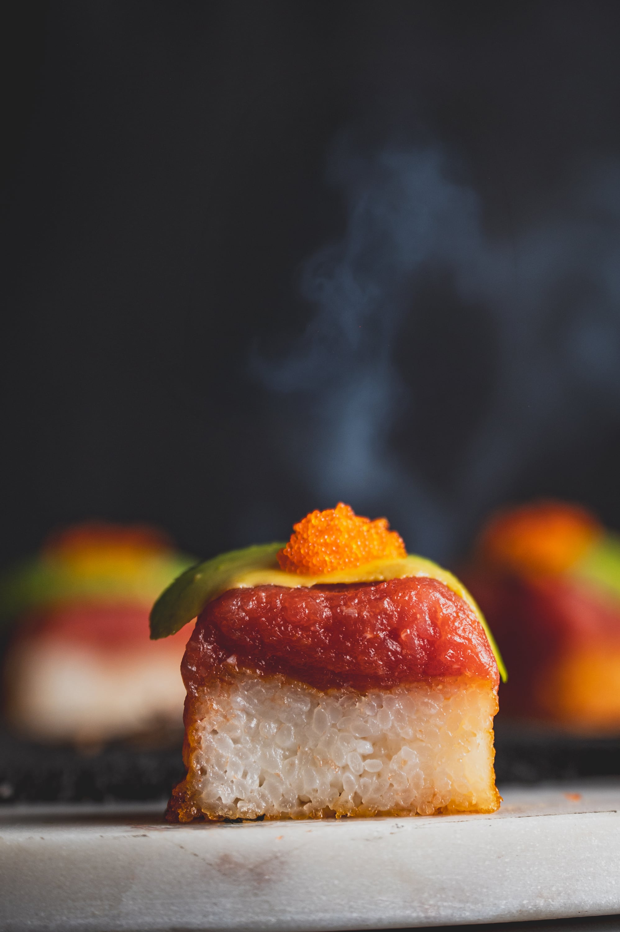 Aburi oshi sushi with tuna and avocado, steam rising