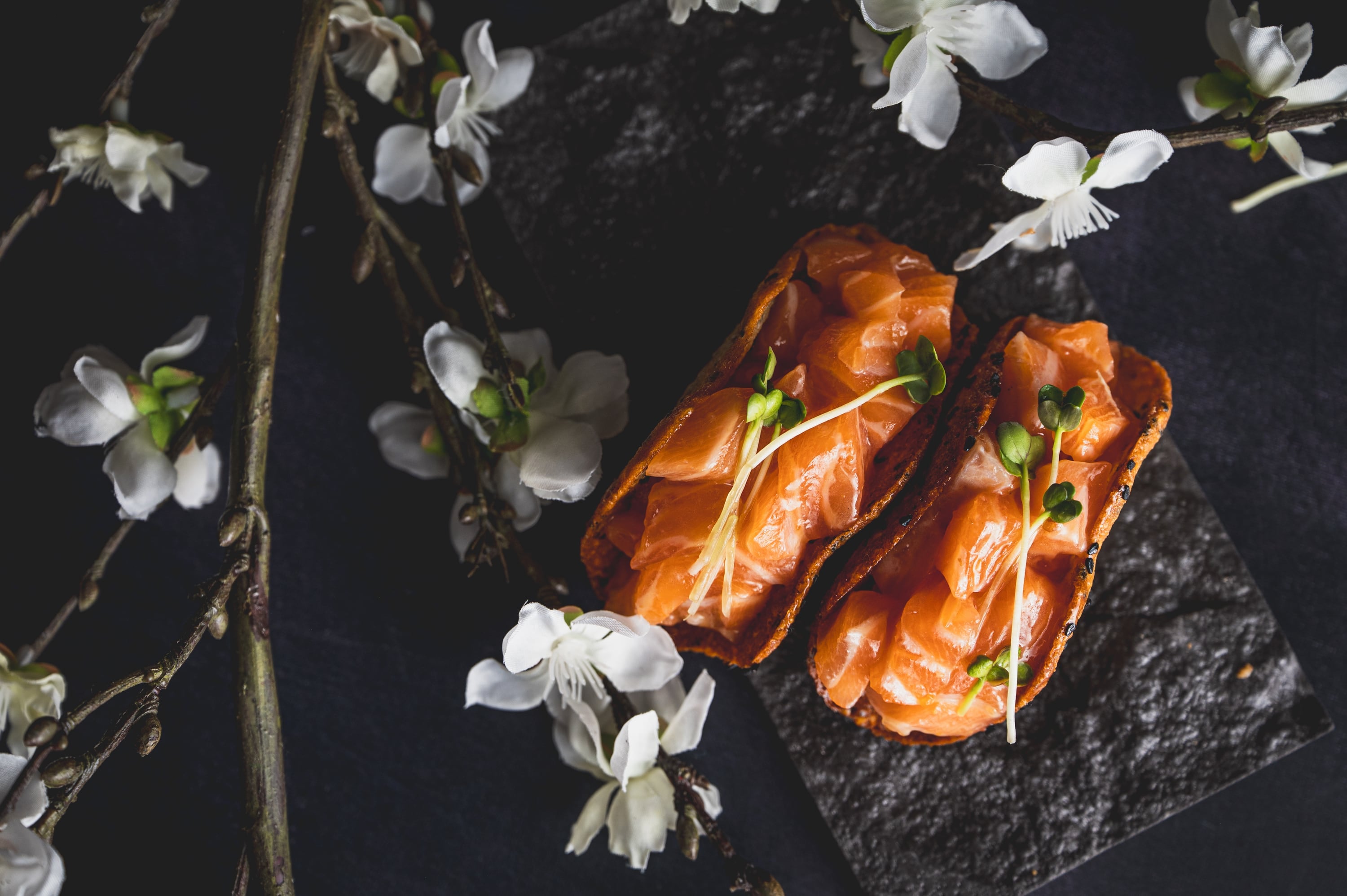 Salmon oshi sushi composed with white blossoms
