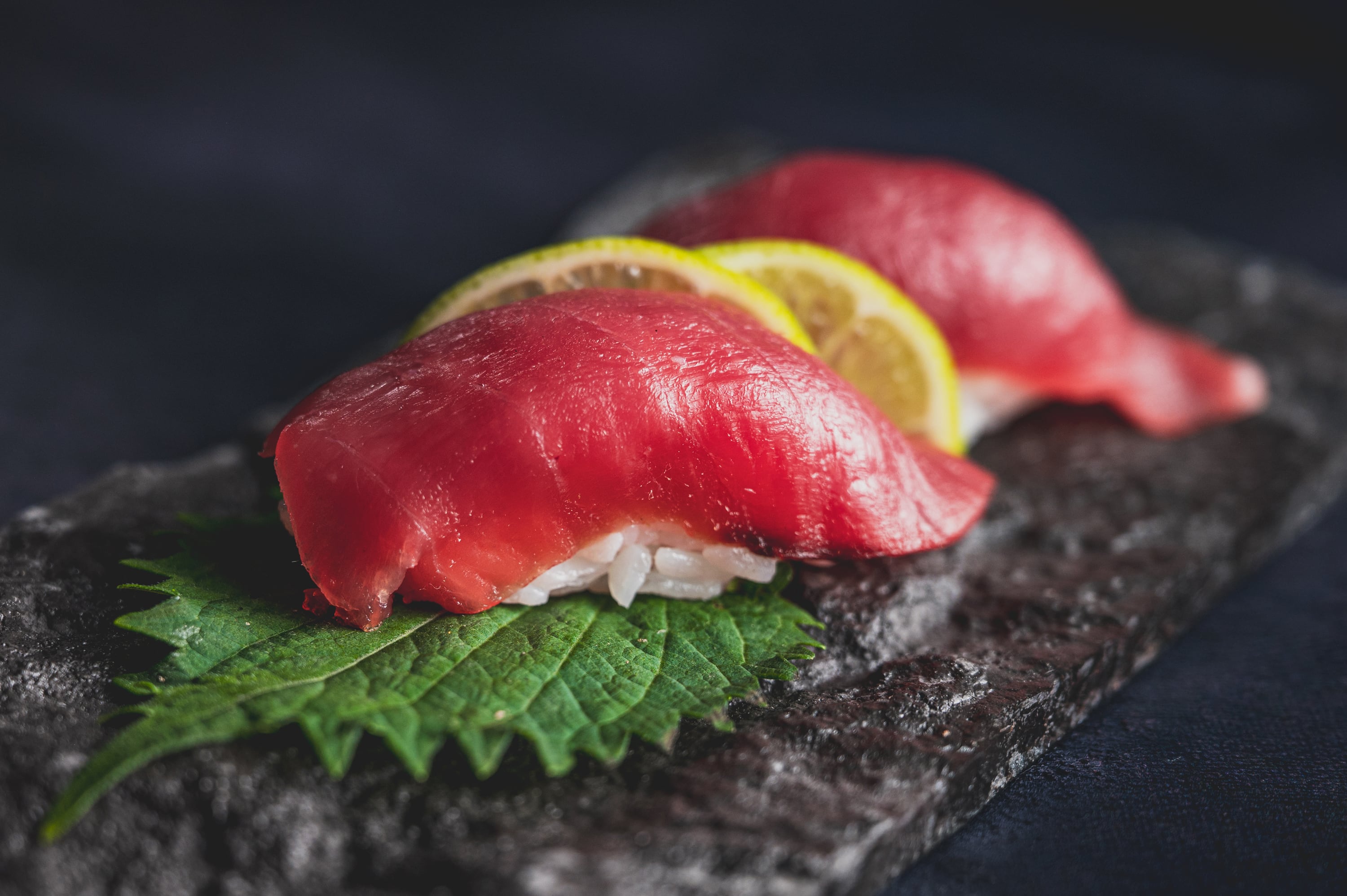 Tuna nigiri on shiso leaf with lemon