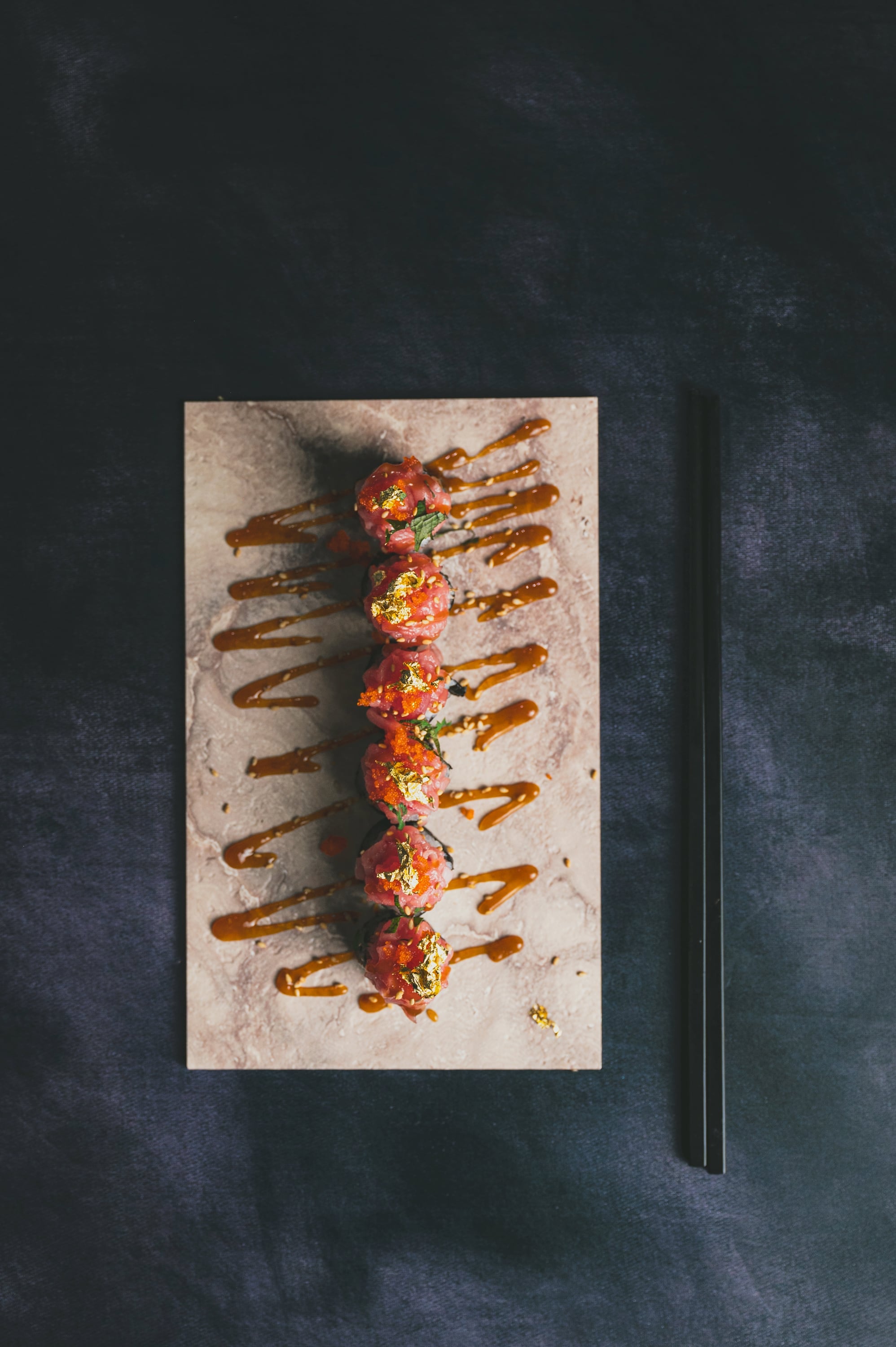 Tuna tartare gunkan with gold leaf and caramel drizzle
